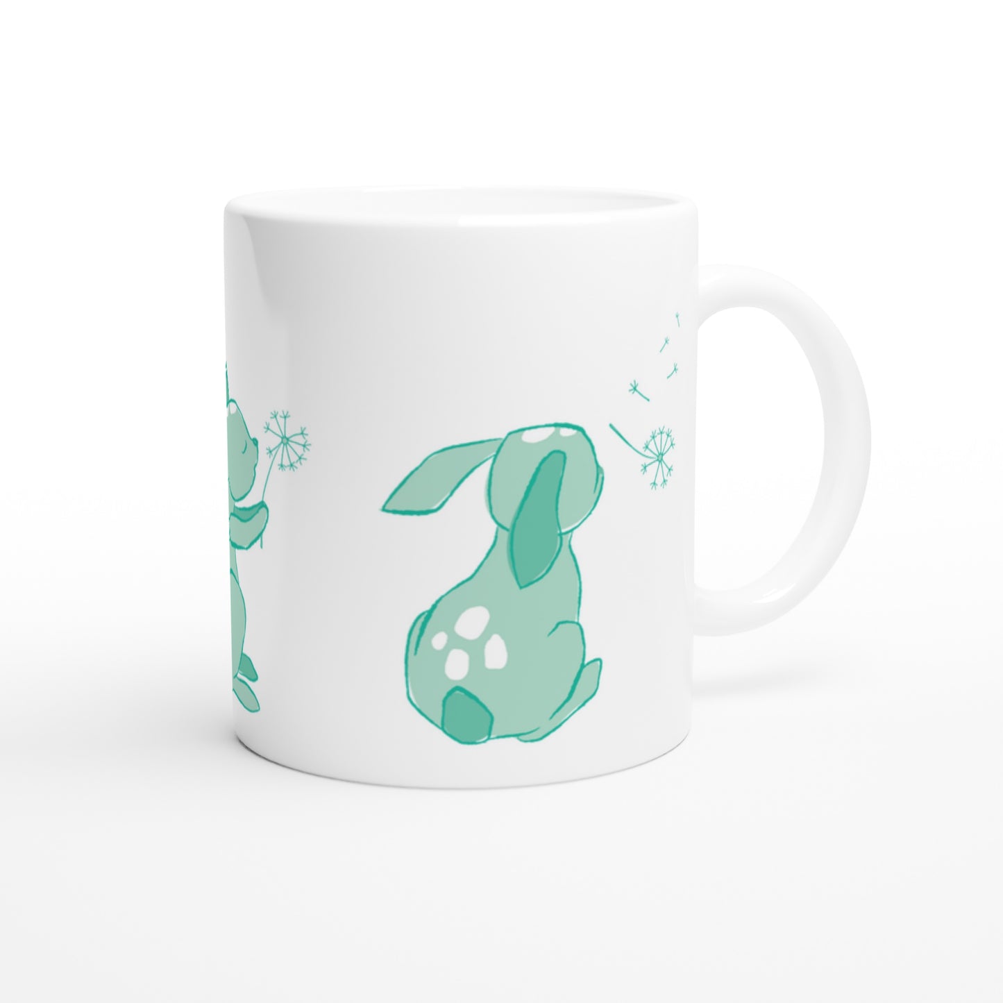 White ceramic mug with a mint green Dandelion and hare print.