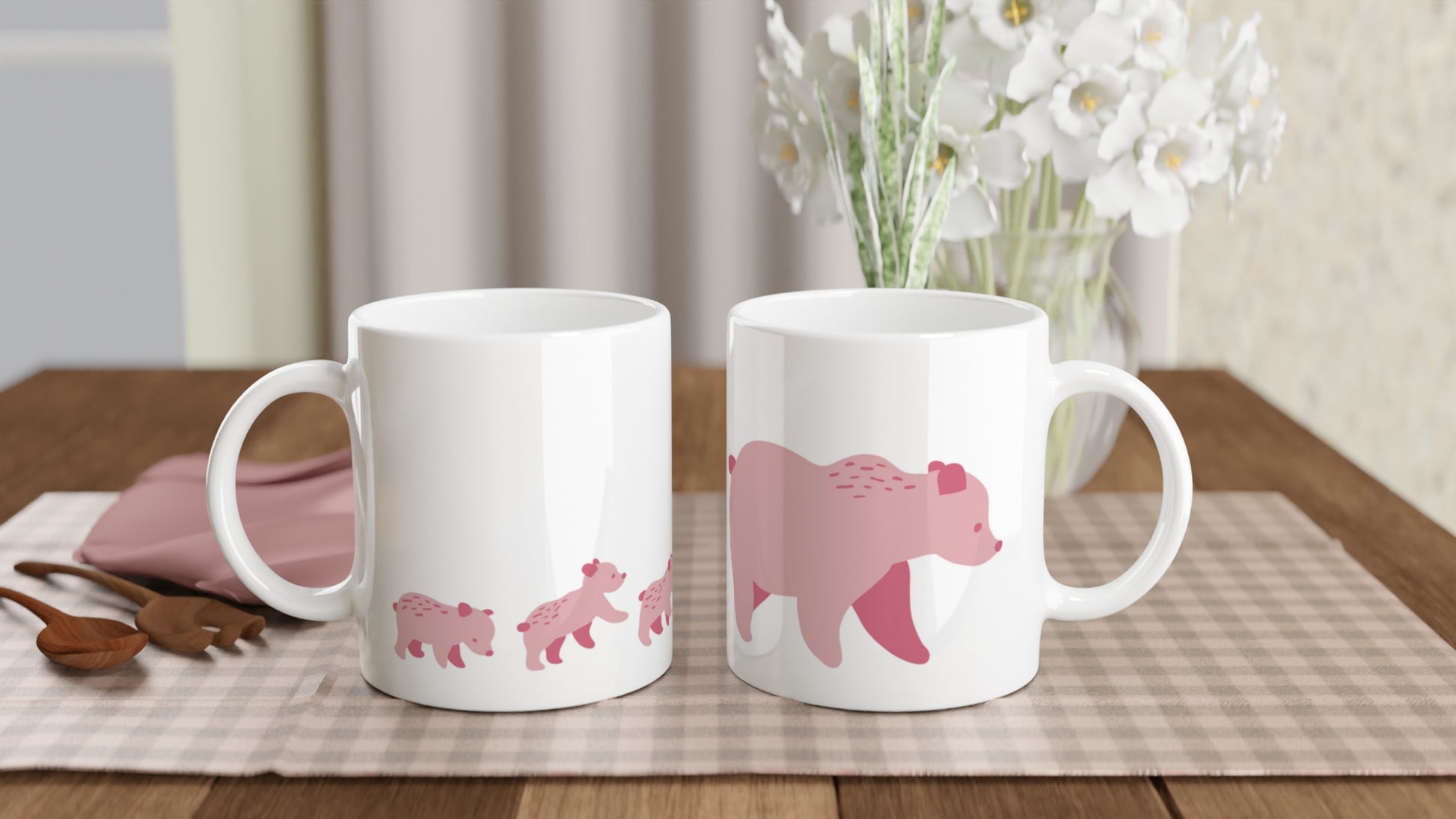 White ceramic mugs with a pink bear family print.