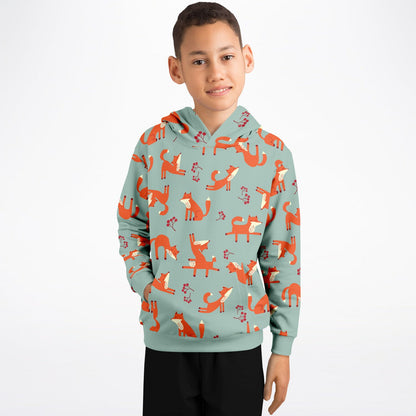 A boy wearing a lichen green hoodie with playful fox pattern.