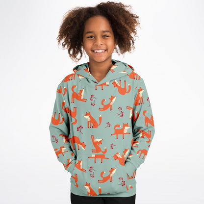 A girl wearing a lichen green hoodie with playful fox pattern.